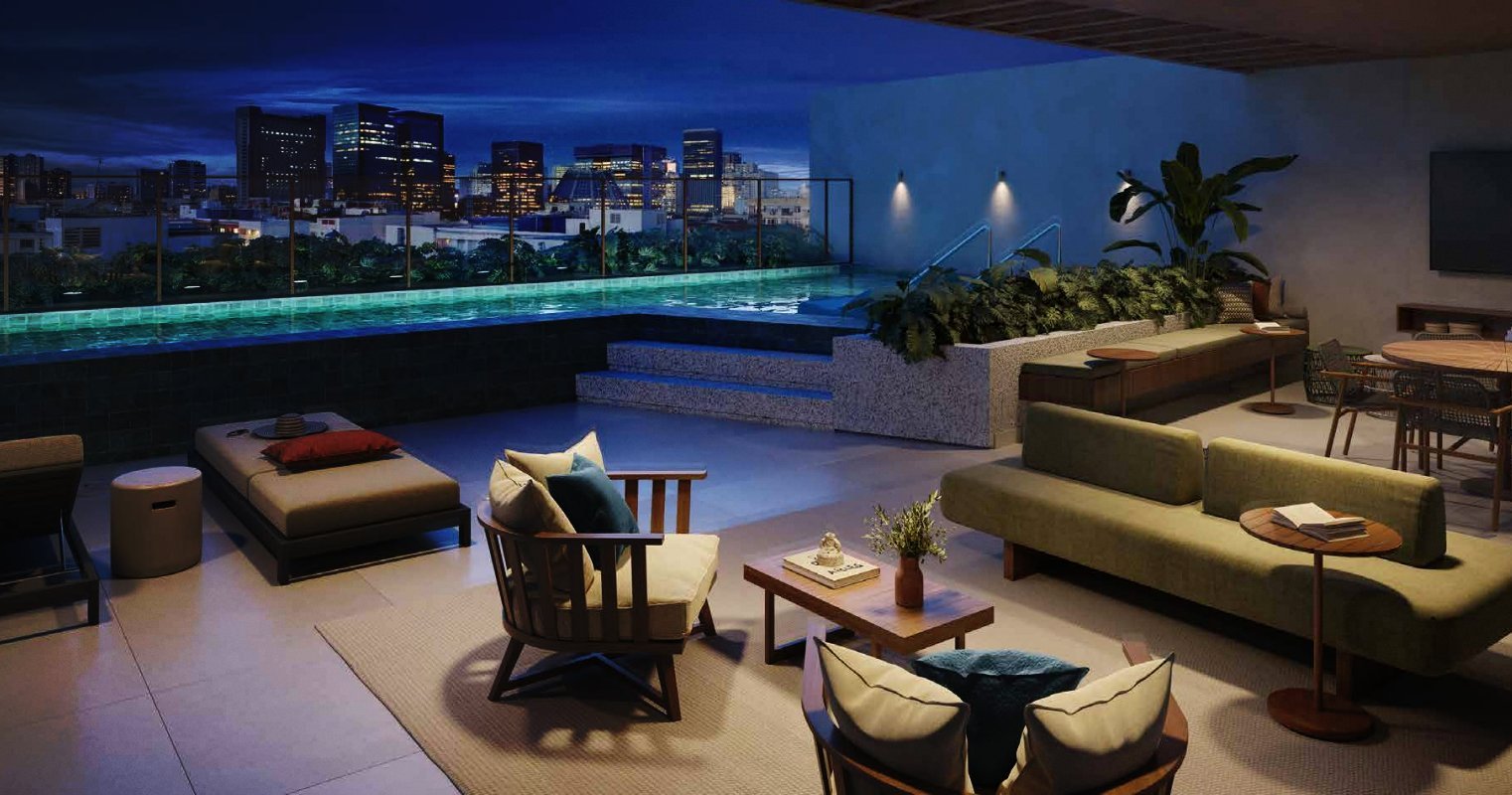 Rooftop do Somos Lapa à noite, com piscina iluminada e vista para o Centro do Rio